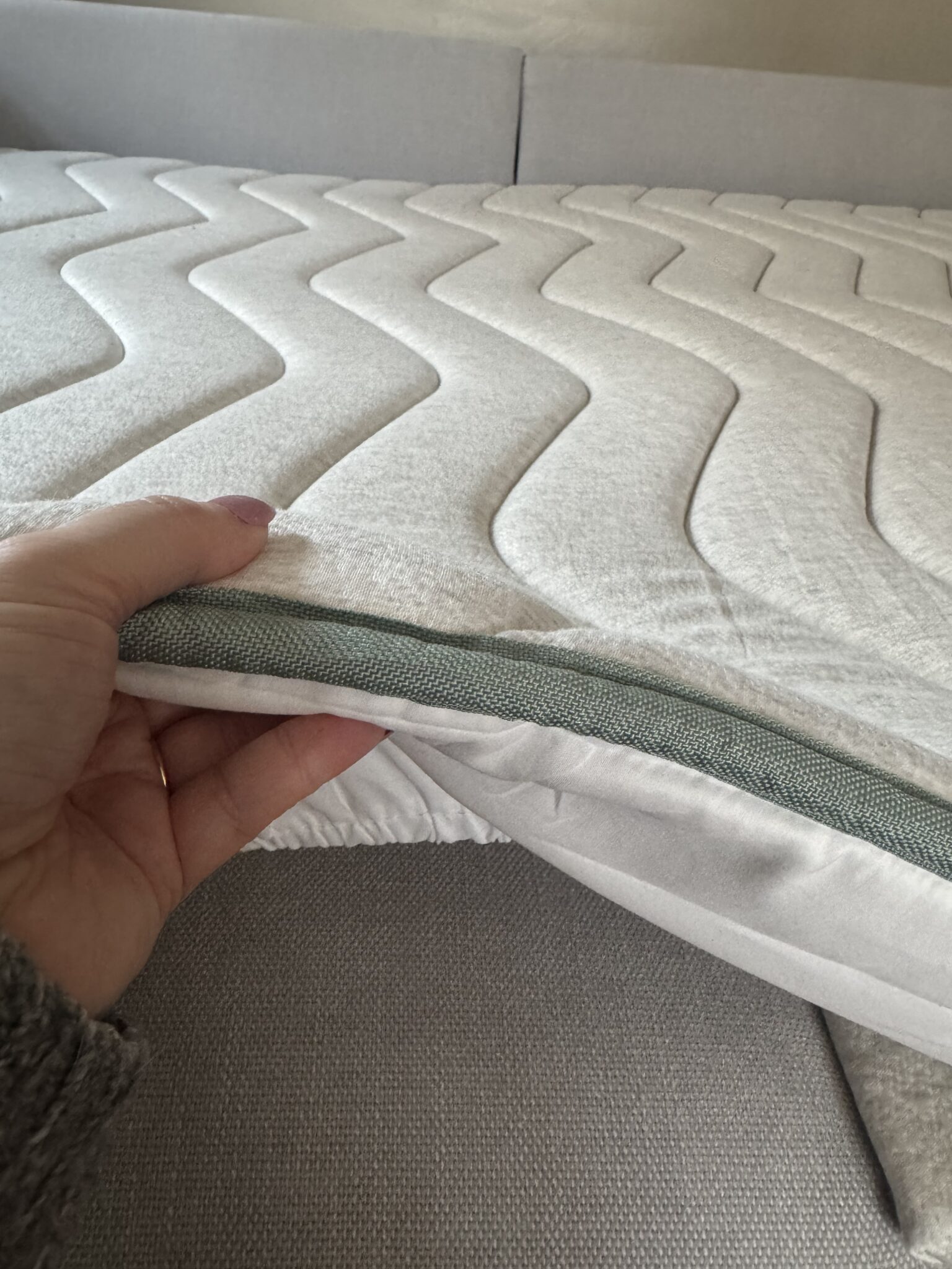 A hand holding a mattress.