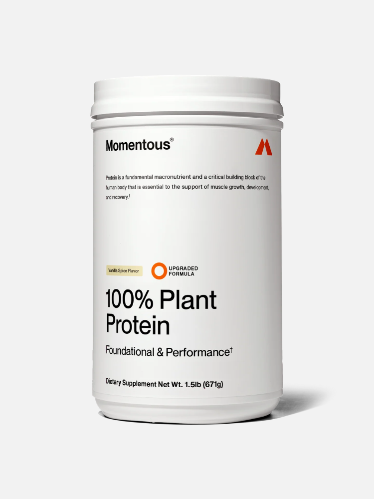 A white container of Momentous 100% Plant Protein Vanilla Spice Flavor, labeled as a dietary supplement with a net weight of 1.5 lb (671g).