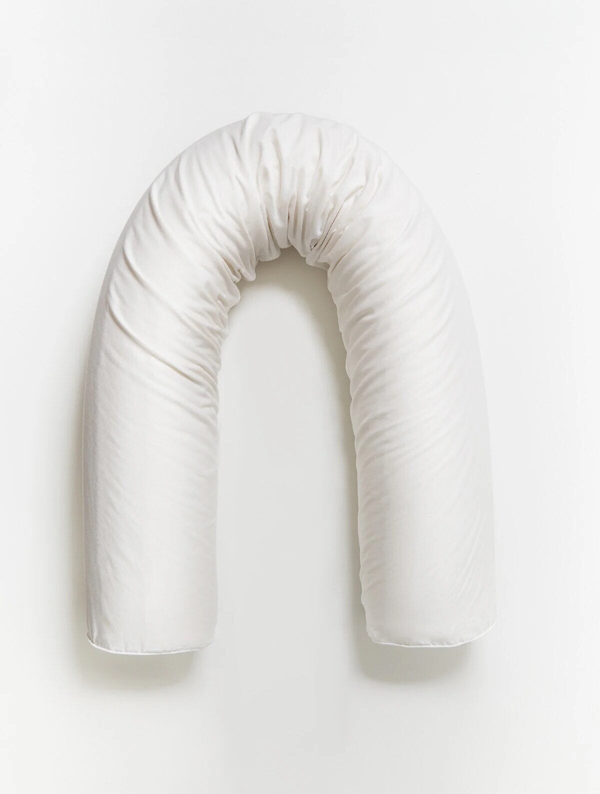 A white, U-shaped body pillow on a plain white background, seen from above.