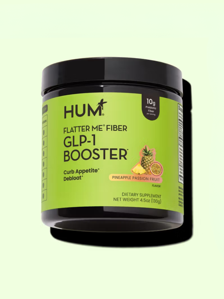 A jar of HUM Flatter Me Fiber GLP-1 Booster dietary supplement for women, pineapple passion fruit flavor, with 10g fiber per serving, is shown against a light green background—ideal for those seeking fiber supplements for women.