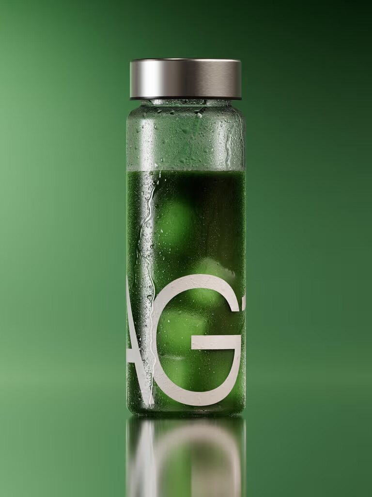 A clear glass bottle with a silver lid containing a green liquid, partially covered in condensation, against a green background with large white letters partially visible.