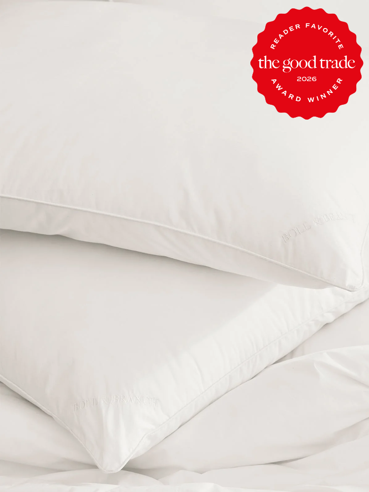 Two white pillows stacked on a white comforter, with a red award badge in the top right corner that reads "The Good Trade Award Winner 2026 Reader Favorite.