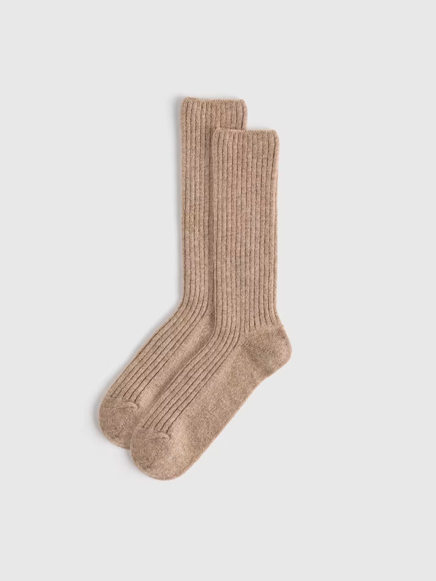 A pair of beige ribbed crew-length organic socks is laid out flat on a plain white background.