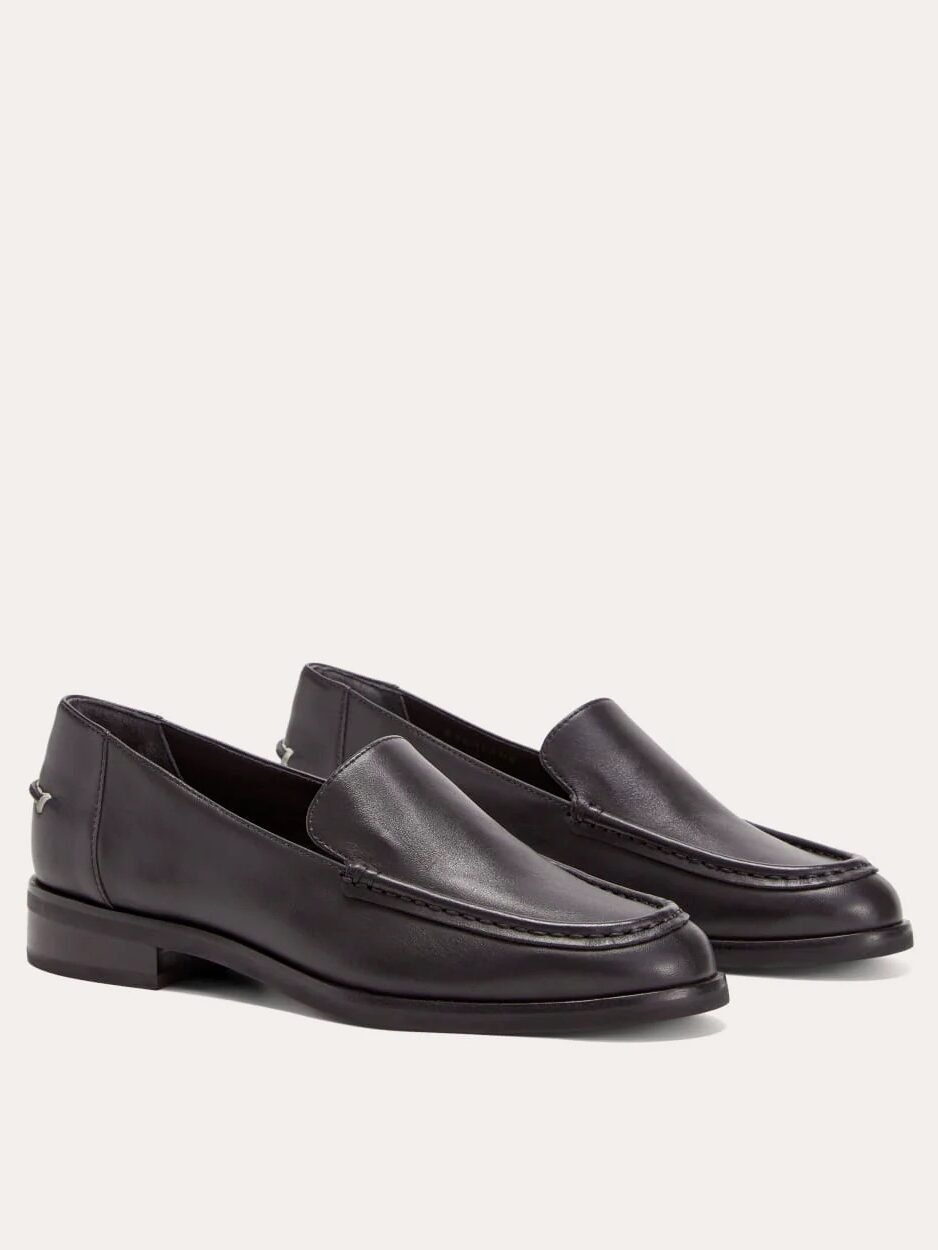 A pair of black leather loafers with low heels and moc toe stitching, displayed against a plain light background.