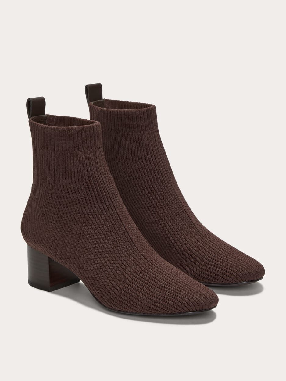 A pair of brown, ribbed knit ankle boots with block heels and pull tabs at the back, displayed on a neutral background.