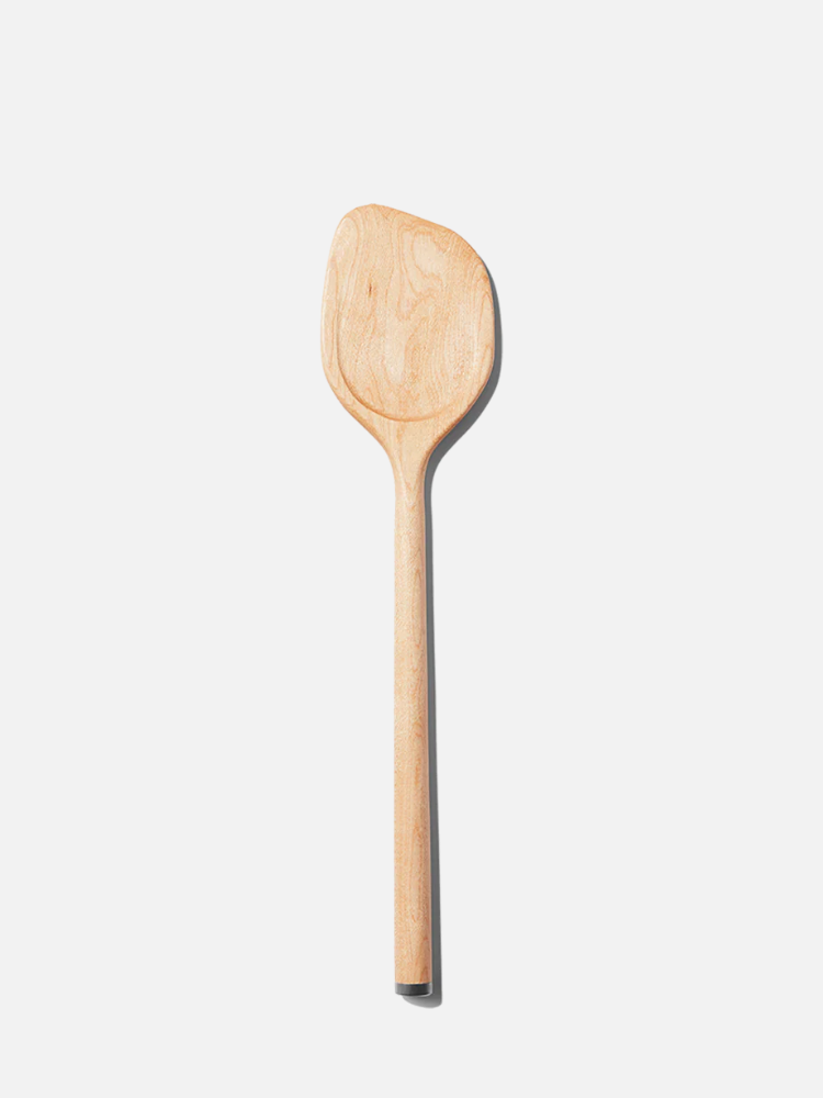 A wooden spoon with a rounded handle and a wide, flat bowl, shown against a plain white background.