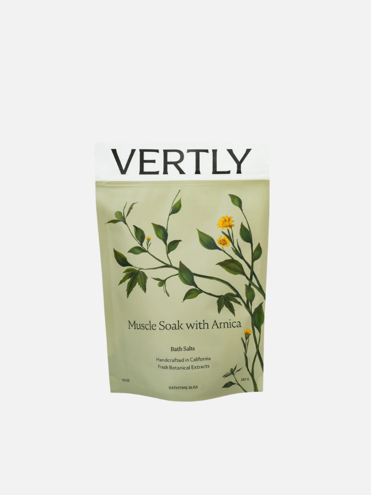 A standing pouch labeled "Vertly Muscle Soak with Arnica" bath salts, featuring botanical illustrations on a light green background.