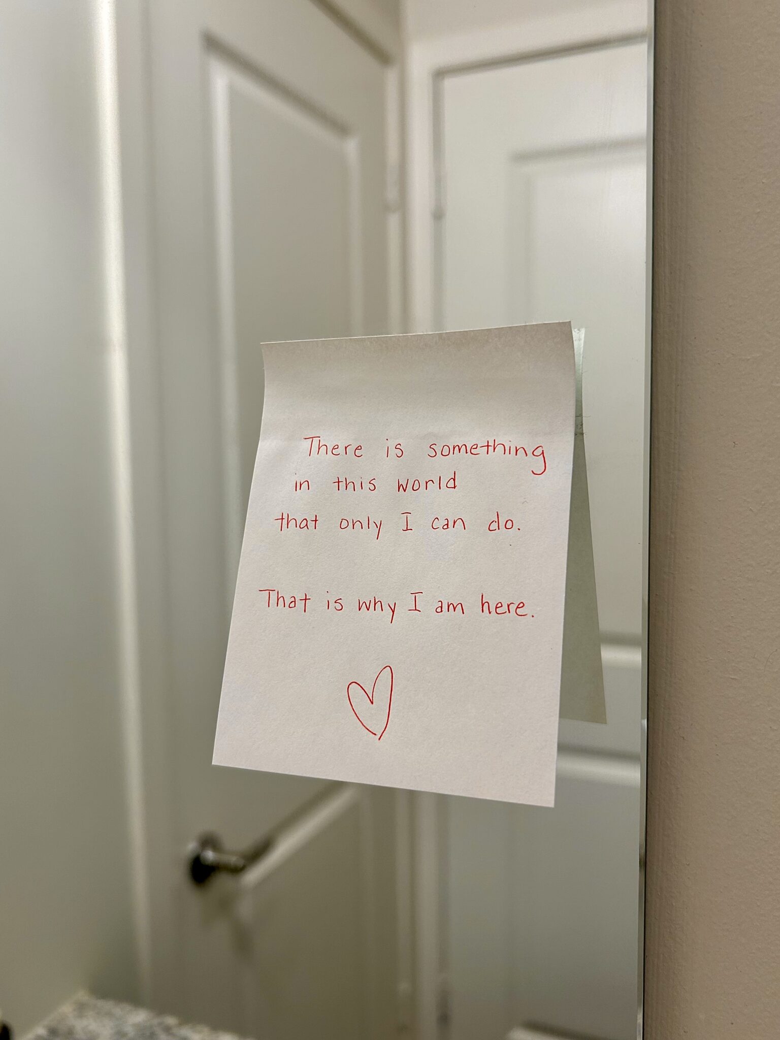 A handwritten note on a bathroom mirror reads, "There is something in this world that only I can do. That is why I am here," followed by a heart symbol.