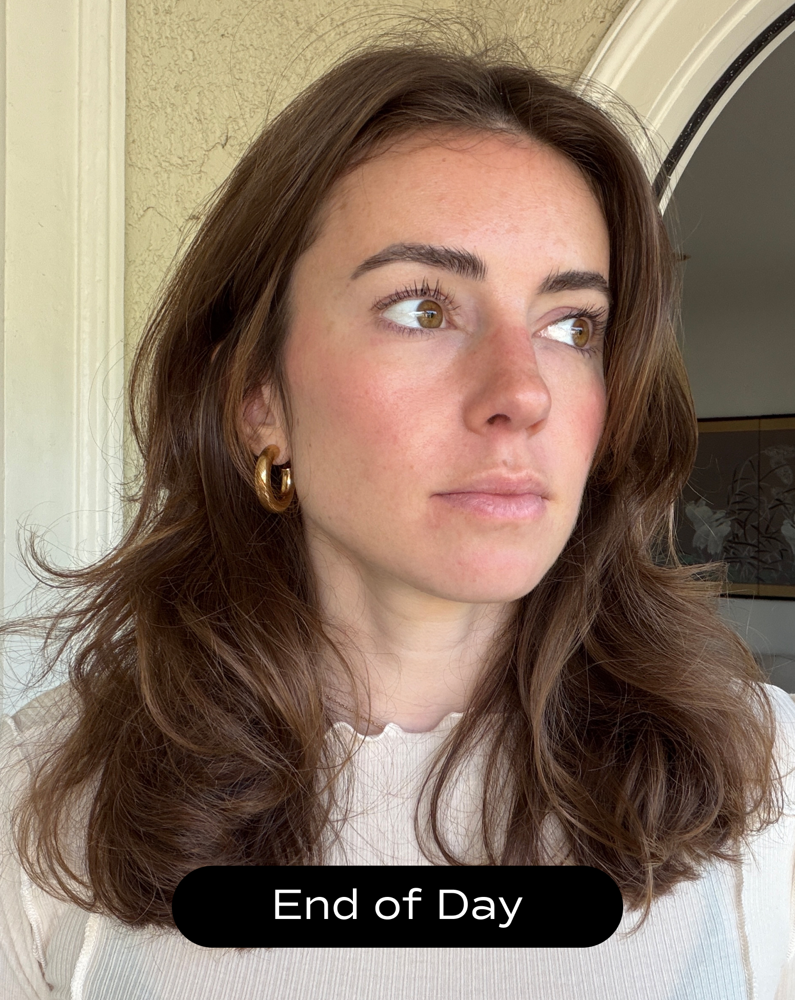 A woman with wavy brown hair and gold hoop earrings looks to the side in natural light. Text at the bottom reads, "End of Day.