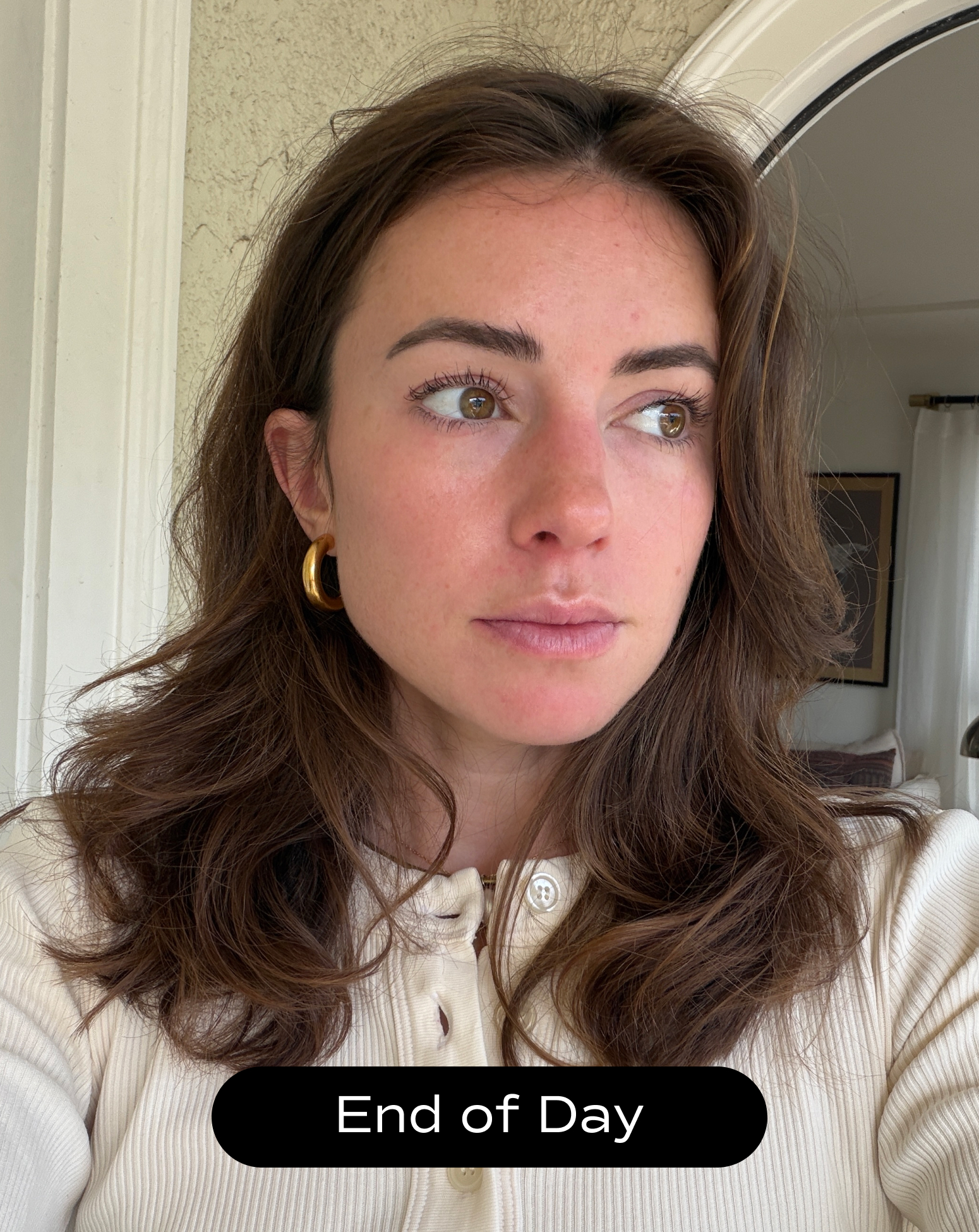 A woman with medium-length brown hair and gold hoop earrings looks to the side indoors, wearing a cream-colored top. Text at the bottom reads "End of Day.
