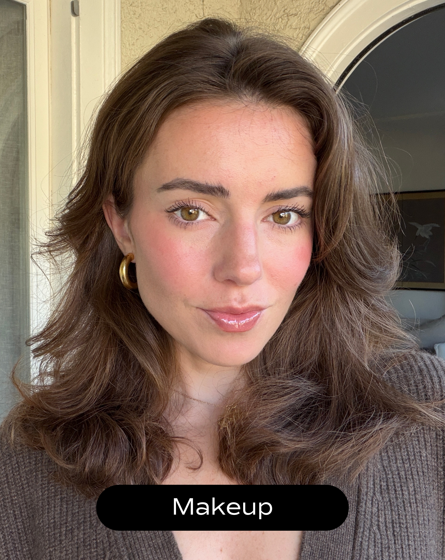 A woman with medium-length brown hair, gold hoop earrings, and natural makeup poses indoors, looking at the camera. The word "Makeup" appears at the bottom of the image.