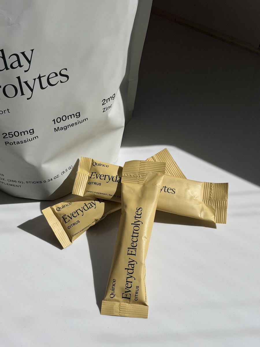 Three yellow sticks labeled "Everyday Electrolytes" lie on a white surface next to a partially visible packet with nutrient information.