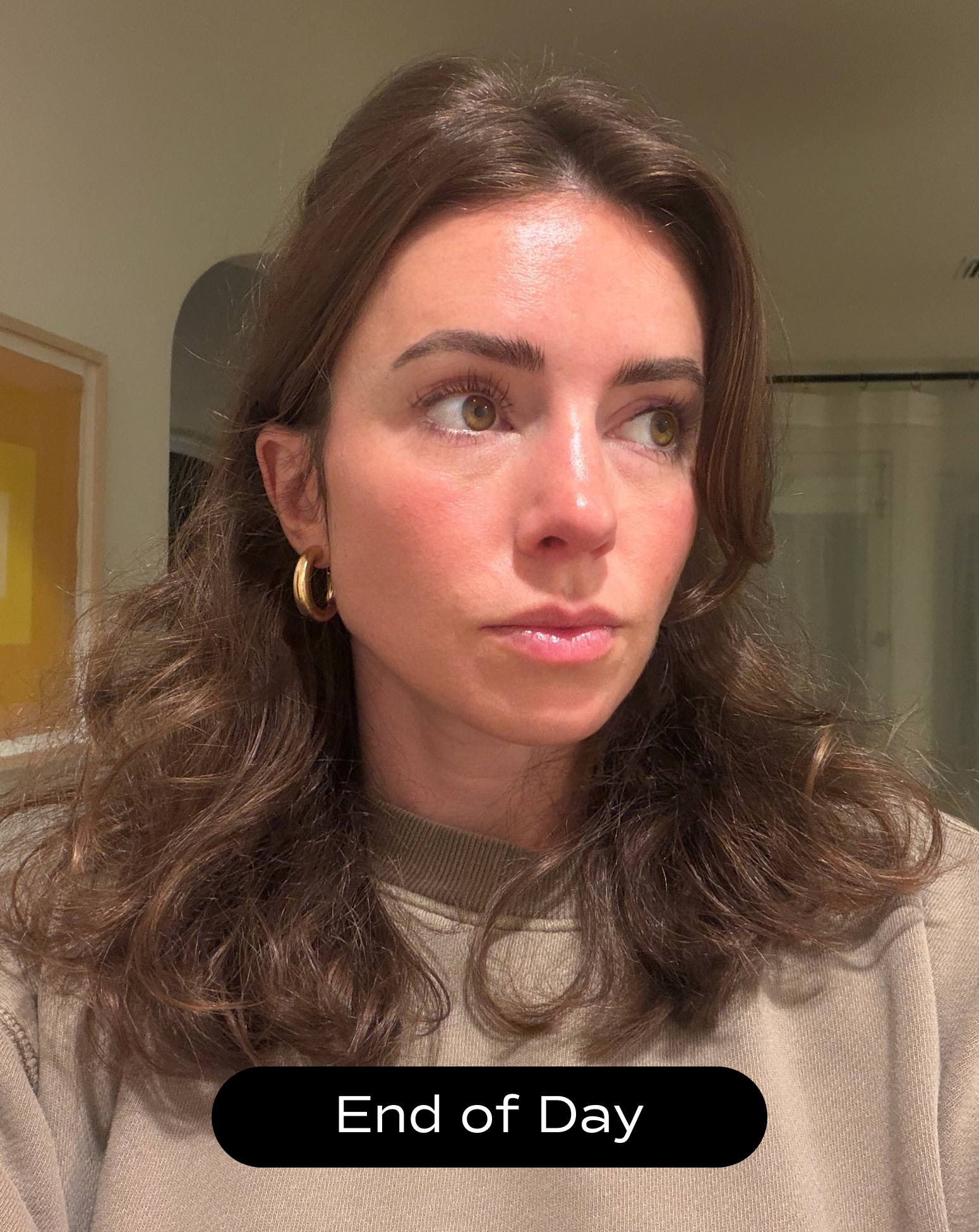 A woman with wavy brown hair and gold hoop earrings looks to the side in a well-lit room. Text at the bottom reads "End of Day.