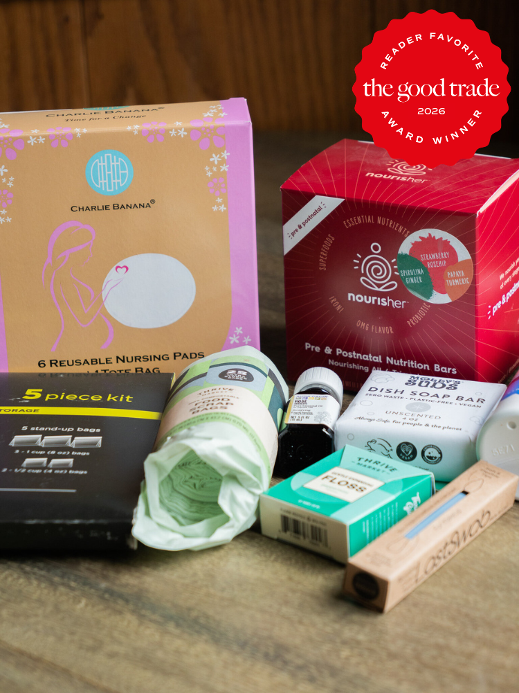 A selection of maternity and postpartum care products, including nursing pads, nutrition bars, a perineal spray, and other personal care items, displayed on a wooden surface.