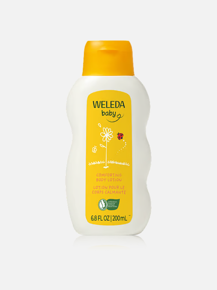A 200 mL bottle of Weleda Baby Comforting Body Lotion with a yellow cap and label featuring simple flower and ladybug illustrations.