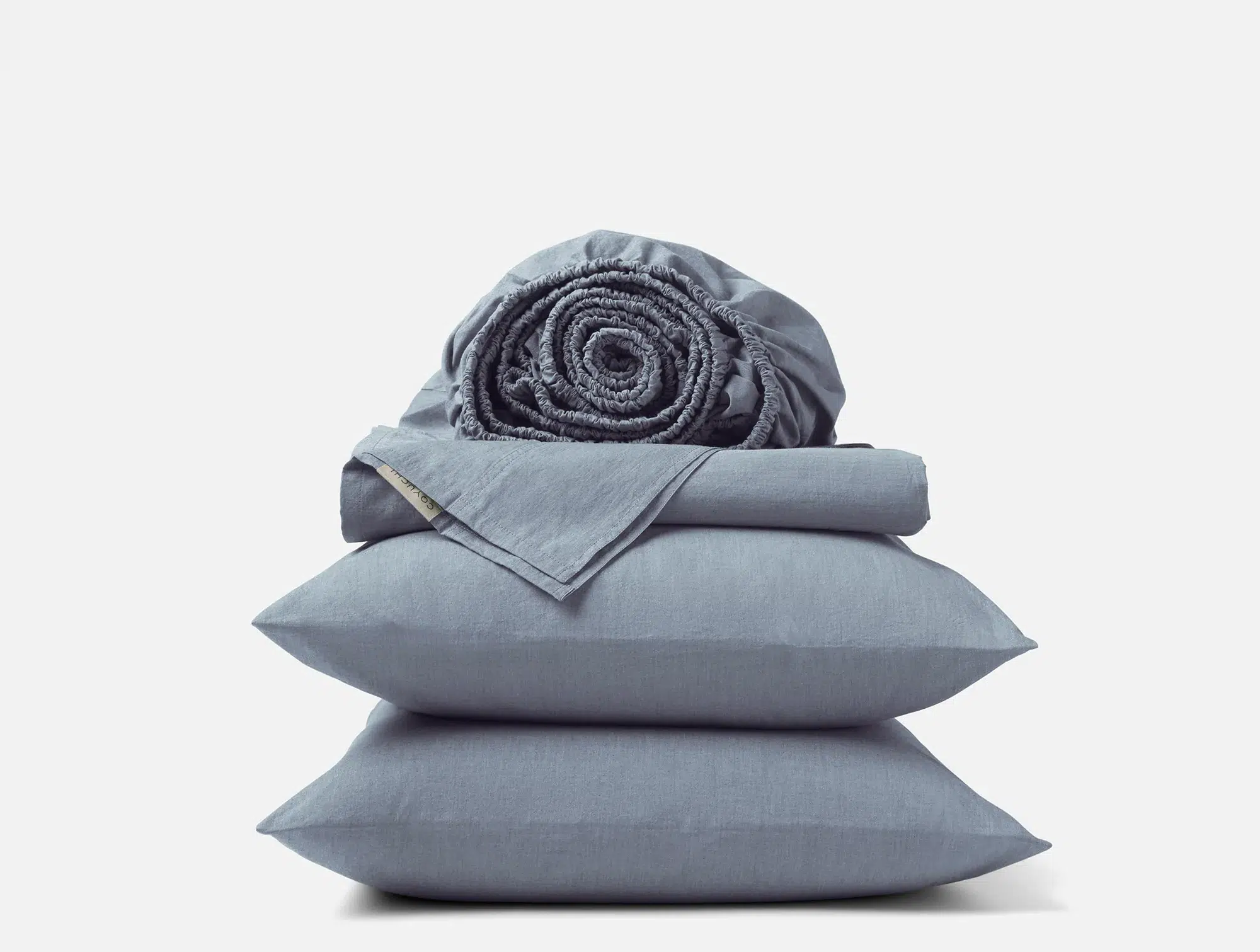 A neatly folded gray bedsheet, a rolled-up gray fitted sheet, and two stacked gray pillows against a plain white background.