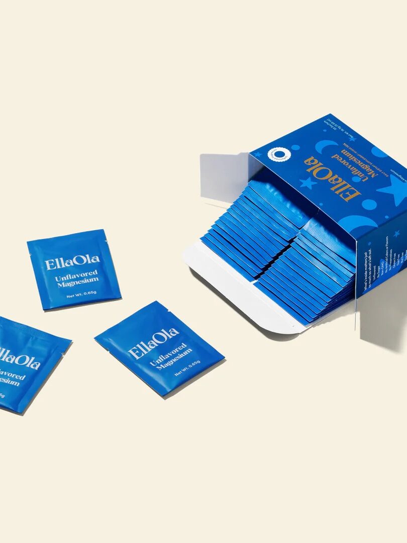 A blue box labeled "EllaOla" with individual blue packets of unscented wipes, some inside the box and three lying outside on a beige background.