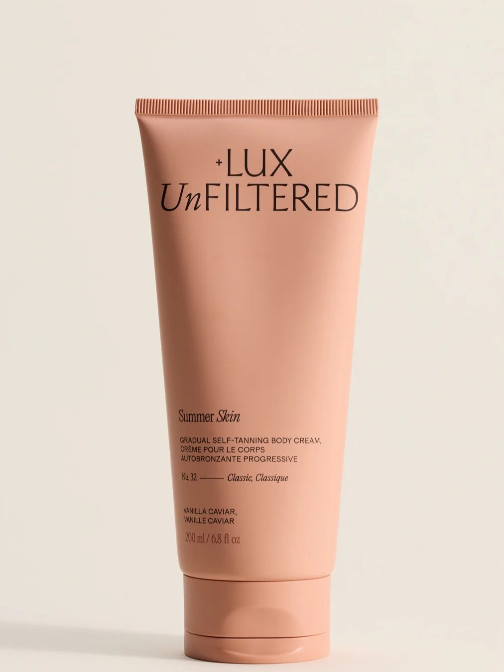 A peach-colored tube of +LUX UNFILTERED Summer Skin gradual self-tanning body cream, 200 ml, vanilla caviar scent, standing upright against a neutral background.