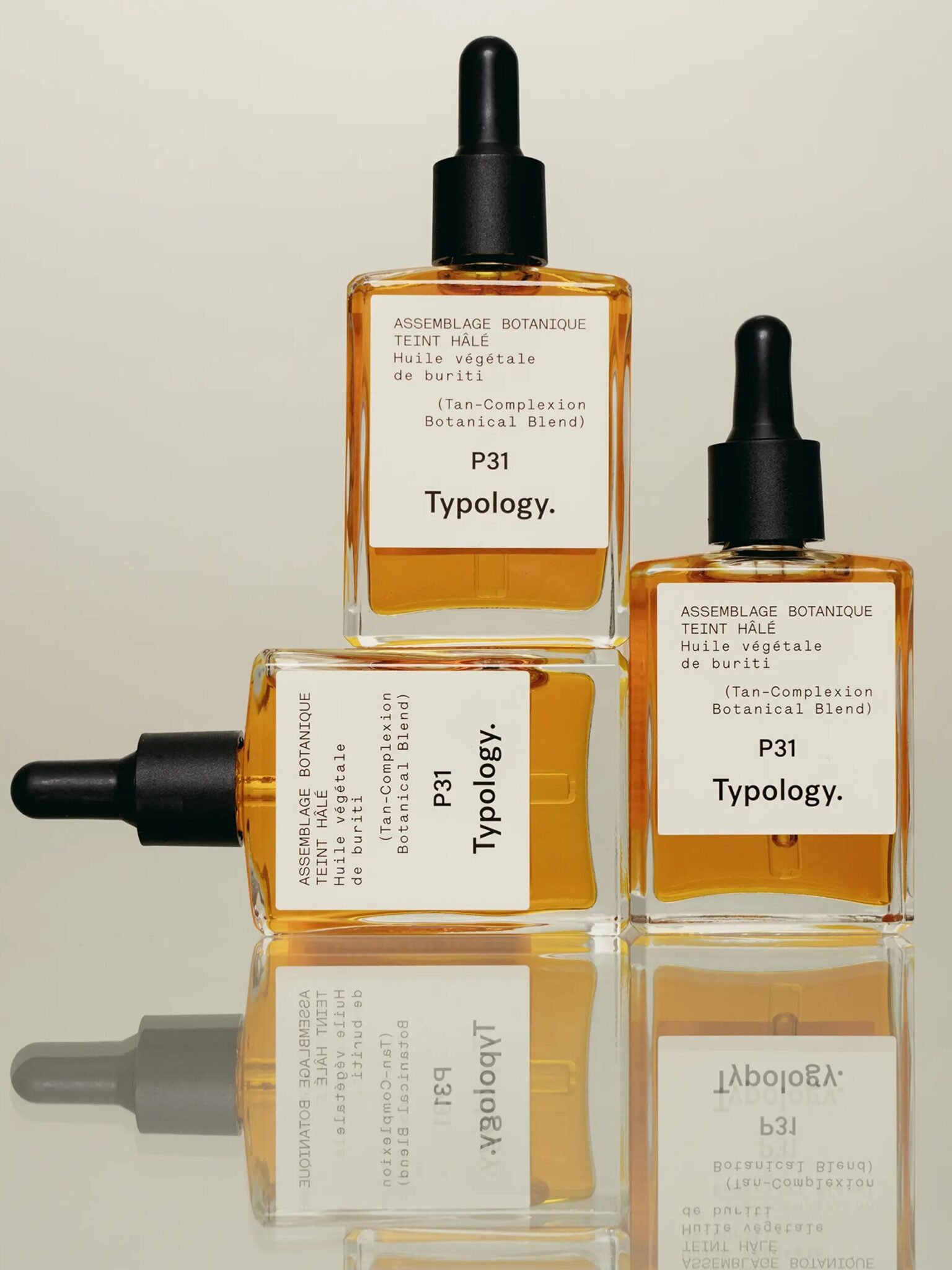 Three Typology P31 Tan-Complexion Botanical Blend serum bottles with droppers are arranged in a stacked formation against a neutral background.