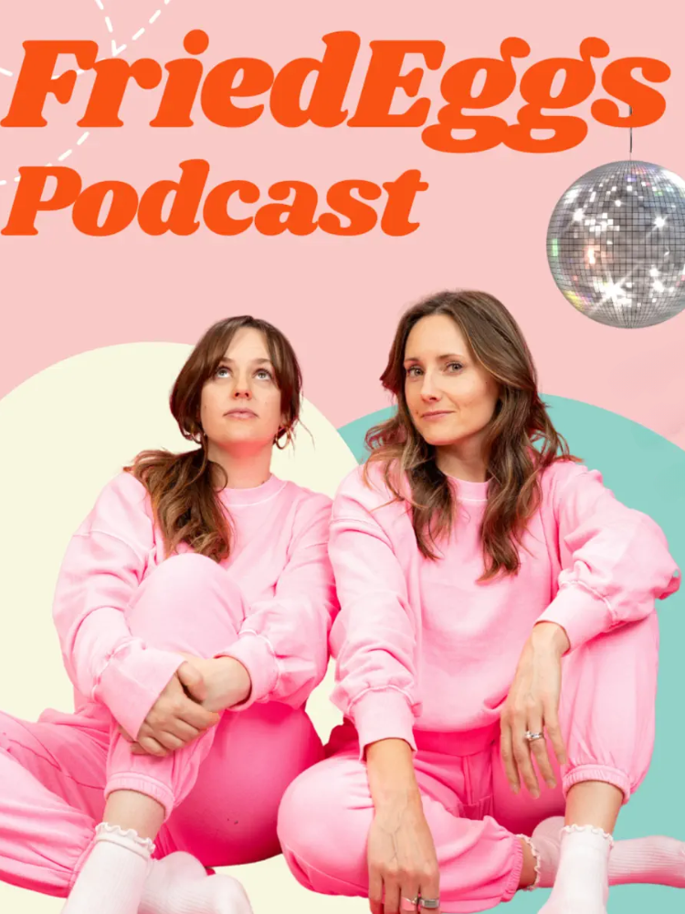 Two women in matching pink sweatsuits sit side by side on a pastel background under the text "Fried Eggs Podcast" with a disco ball above them.