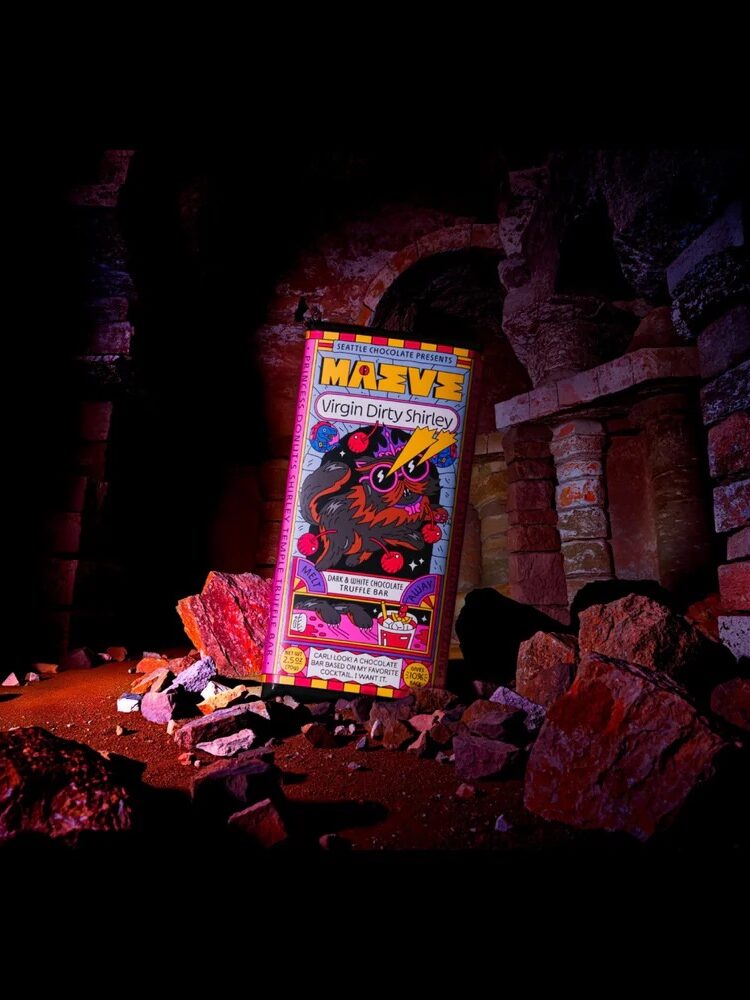 A colorful cereal box labeled "Marvel Virgin Dirty Shrimp" is illuminated among scattered rubble and ancient stone columns in a dark, cave-like setting.