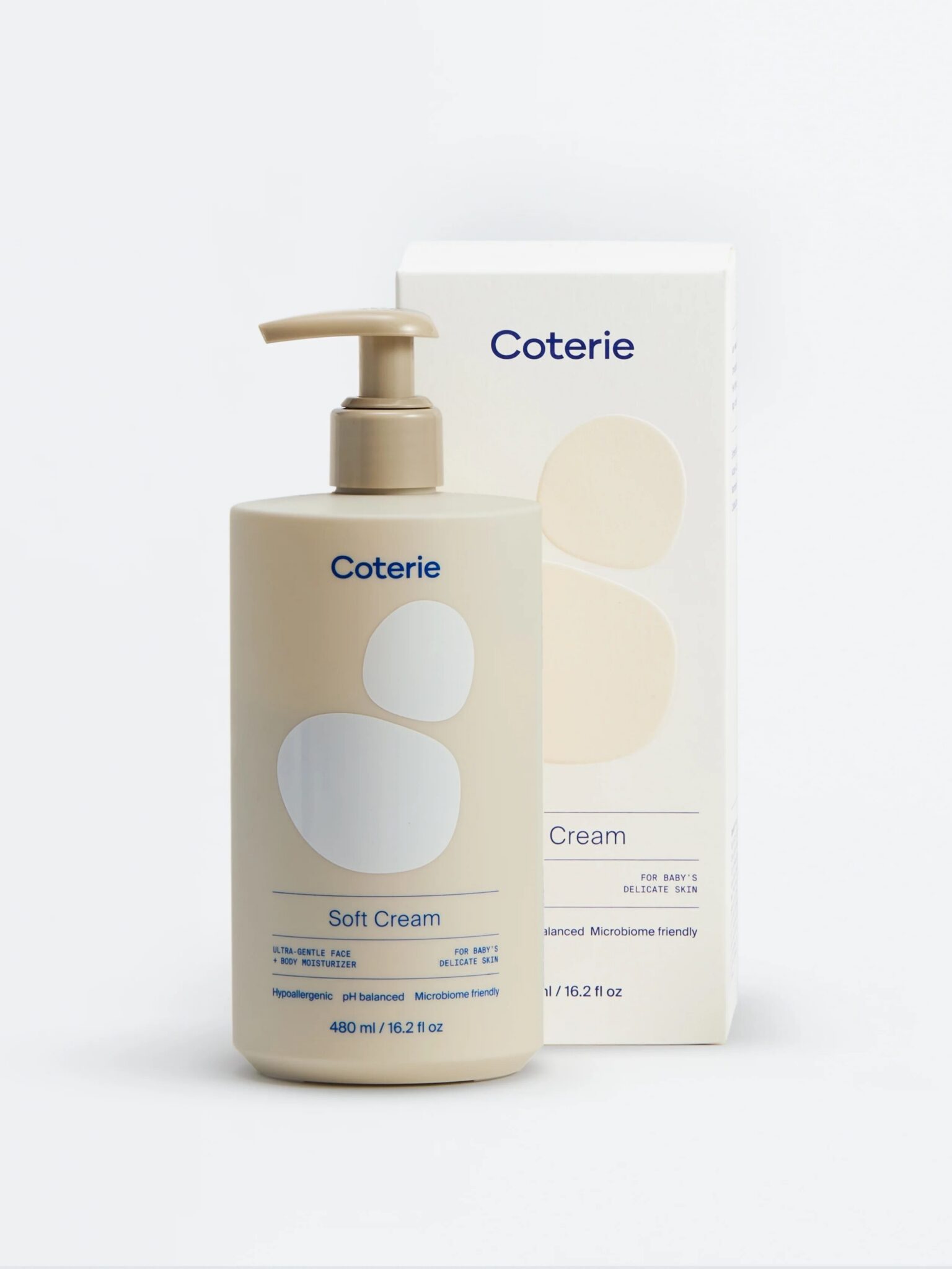 A beige pump bottle labeled "Coterie Soft Cream" is placed in front of a matching product box with abstract shapes and blue text.
