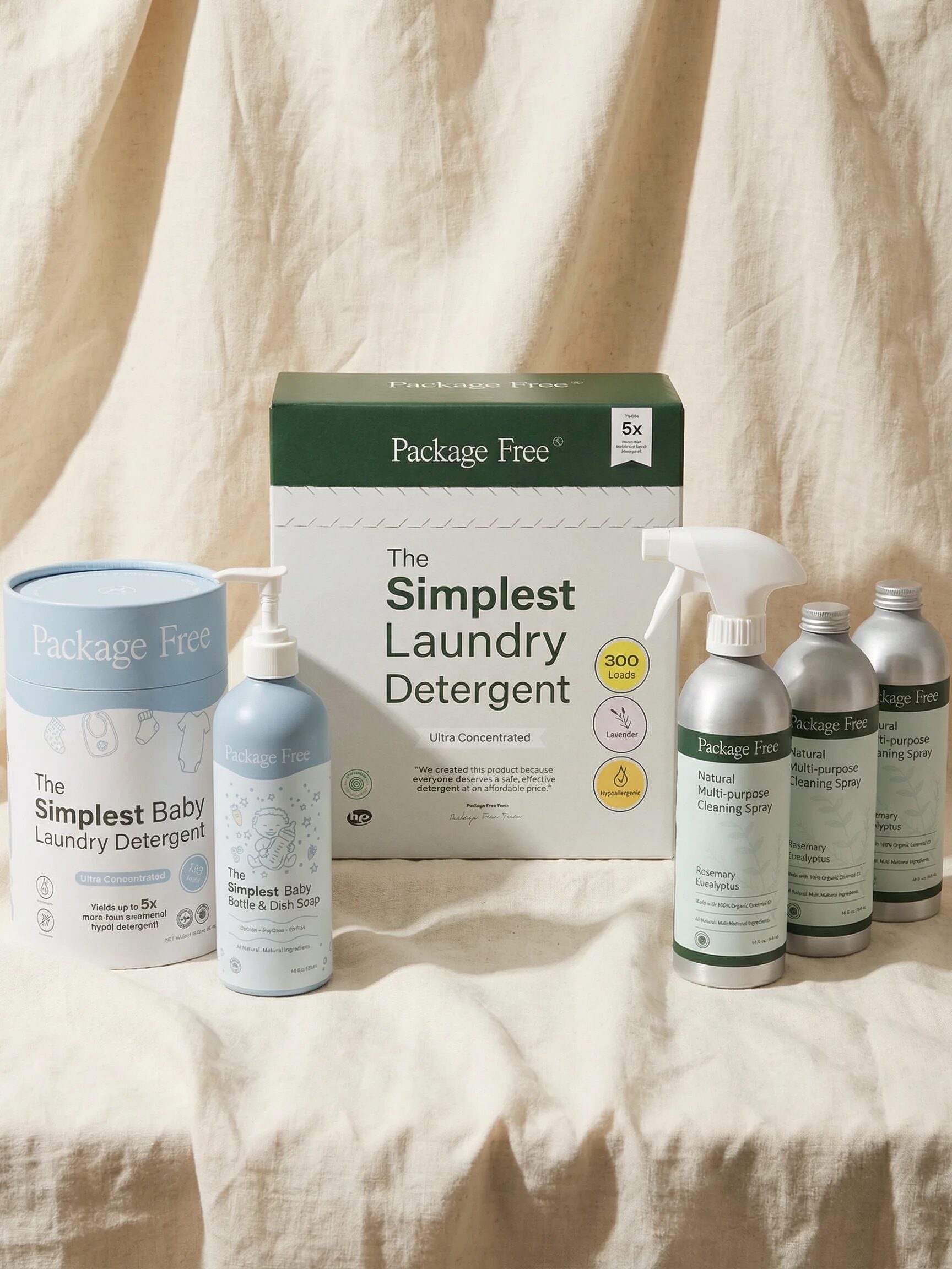 A selection of Package Free brand cleaning products, including laundry detergents and cleaning sprays, arranged on a beige fabric background.