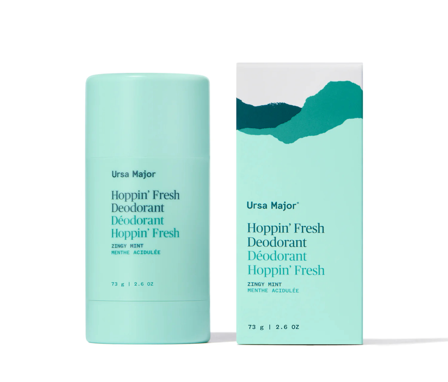 A turquoise stick of Ursa Major Hoppin’ Fresh Deodorant stands next to its matching box, featuring minimalistic green mountain artwork and bilingual English-French text.
