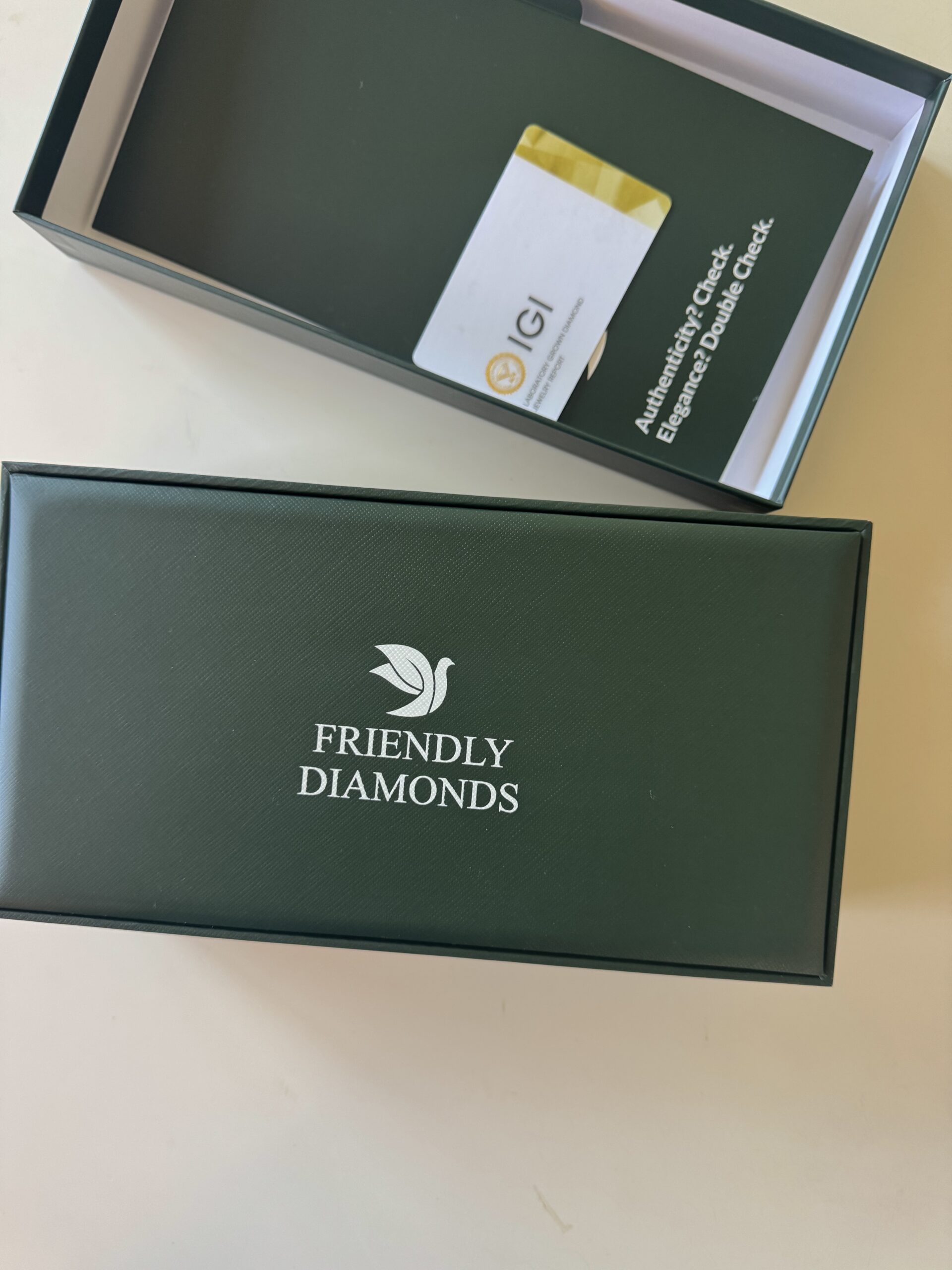 A dark green box labeled "Friendly Diamonds" sits next to its open lid, revealing a card inside the box labeled "IGI Authentication.