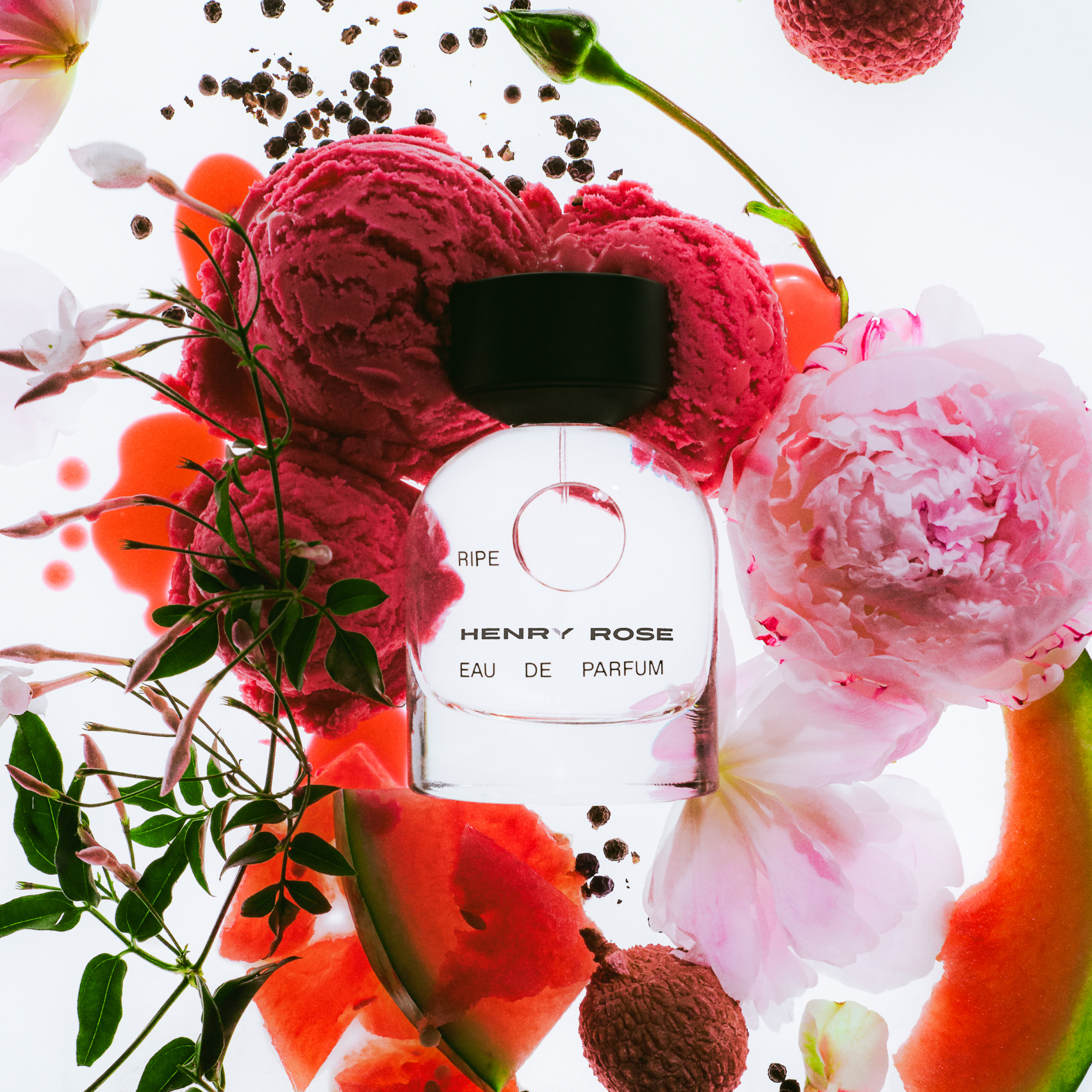A Henry Rose "Ripe" Eau de Parfum bottle is surrounded by pink flowers, berries, peppercorns, and watermelon slices on a white background.