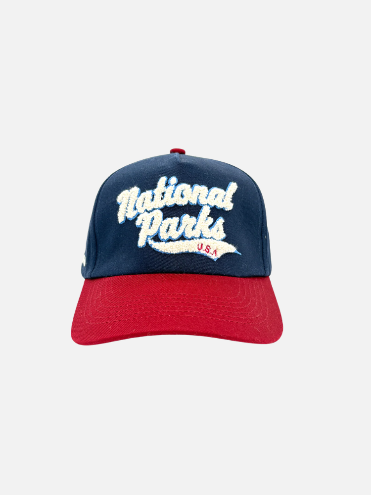 A blue and red baseball cap with white embroidered text reading "National Parks U.S.A." on the front, shown against a plain white background.