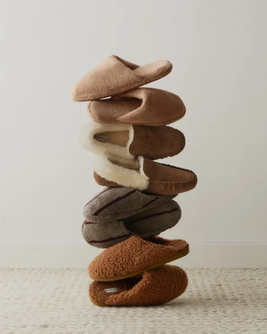 A vertical stack of six assorted Parachute slippers.