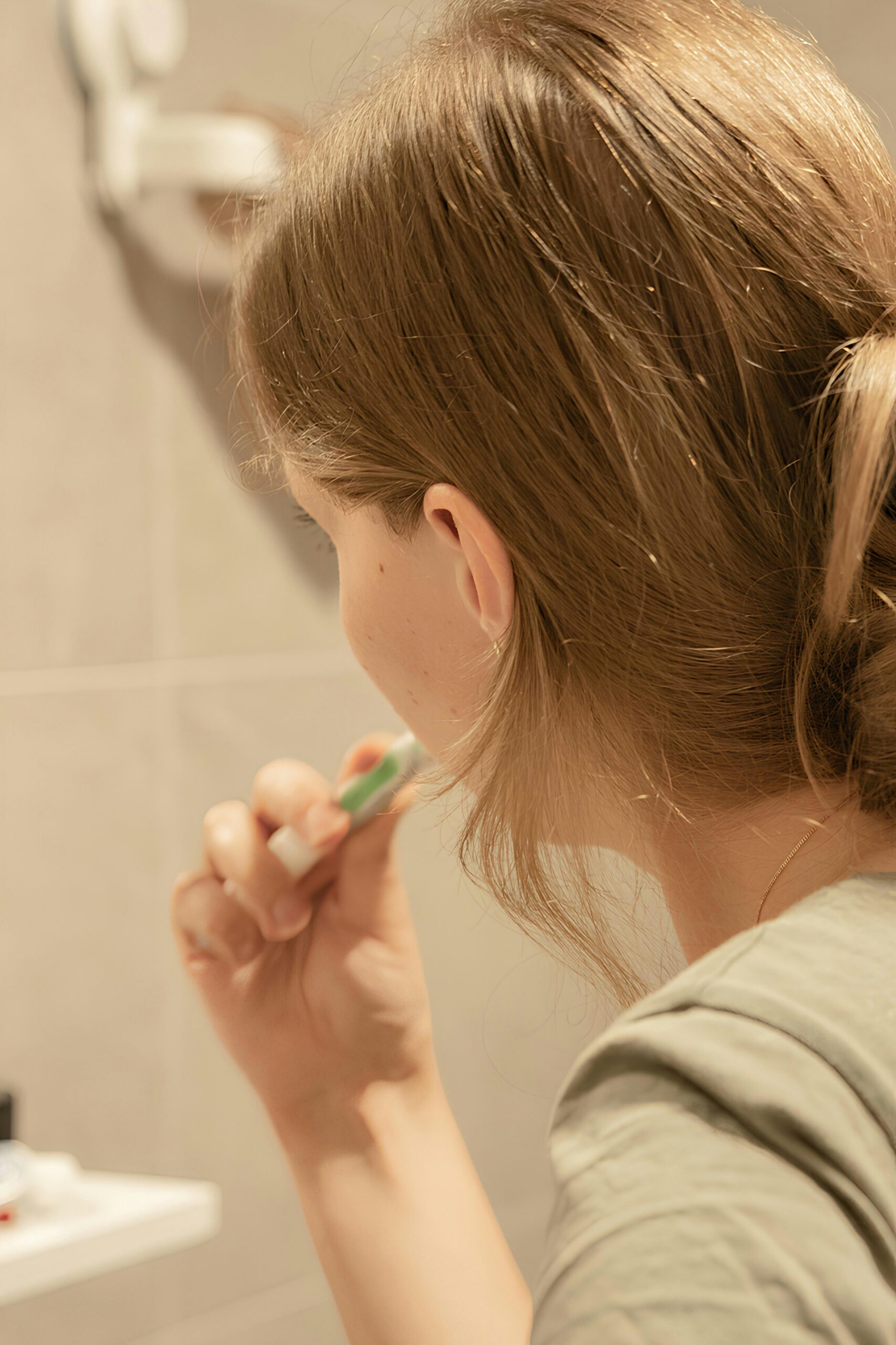 A person brushing their teeth in front of a mirror.